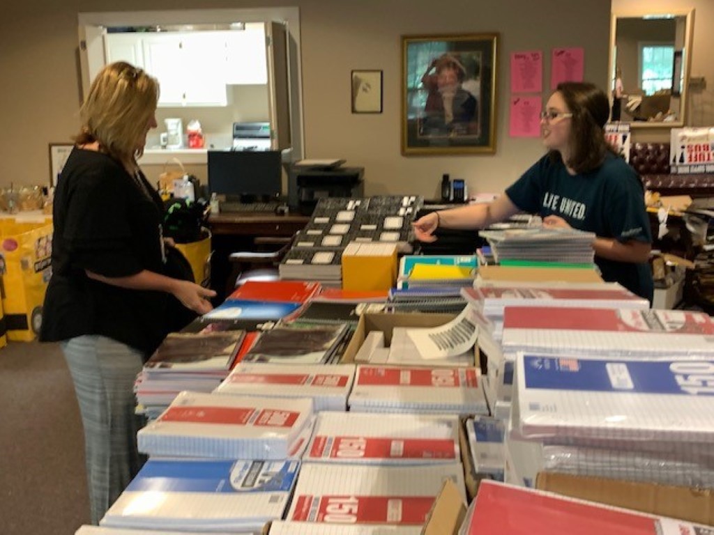 Volunteers sorting donations and packing backpacks