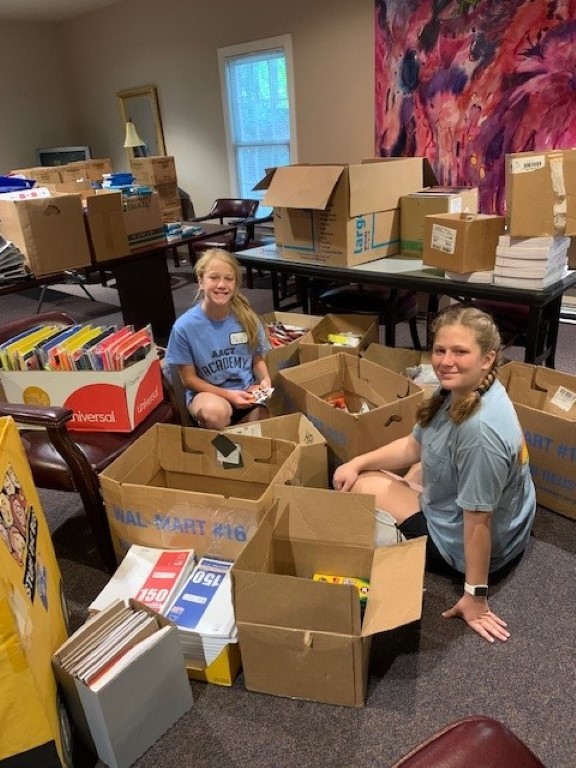 Volunteers sorting donations and packing backpacks