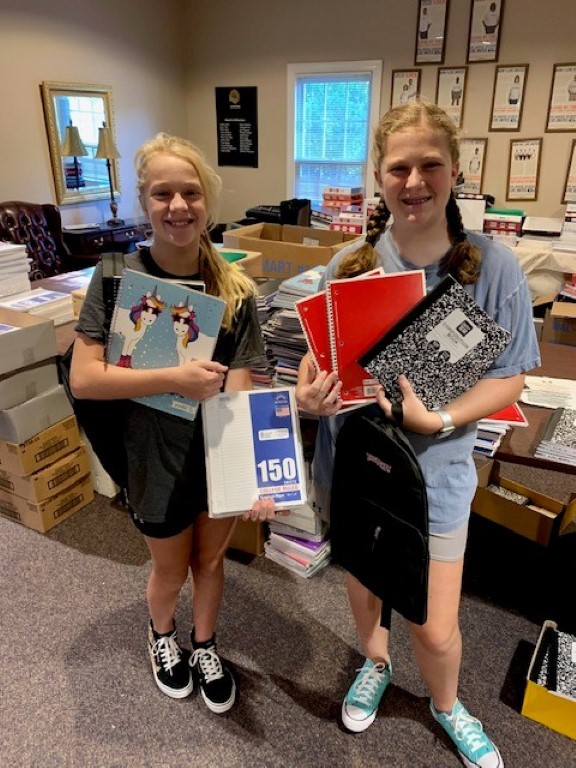 Volunteers sorting donations and packing backpacks