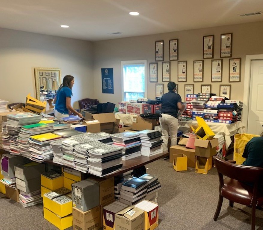 Volunteers sorting donations and packing backpacks