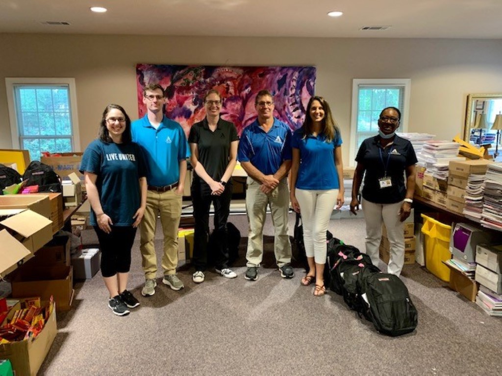 Volunteers sorting donations and packing backpacks