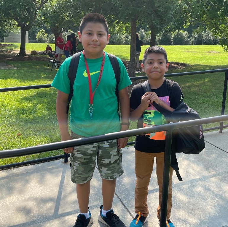 Two boys posing with their new backpacks