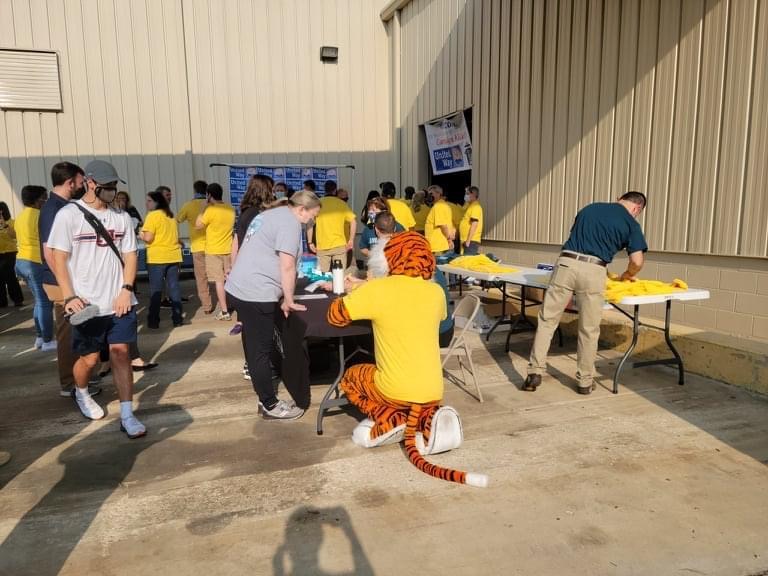 Volunteers and Aubie packing food