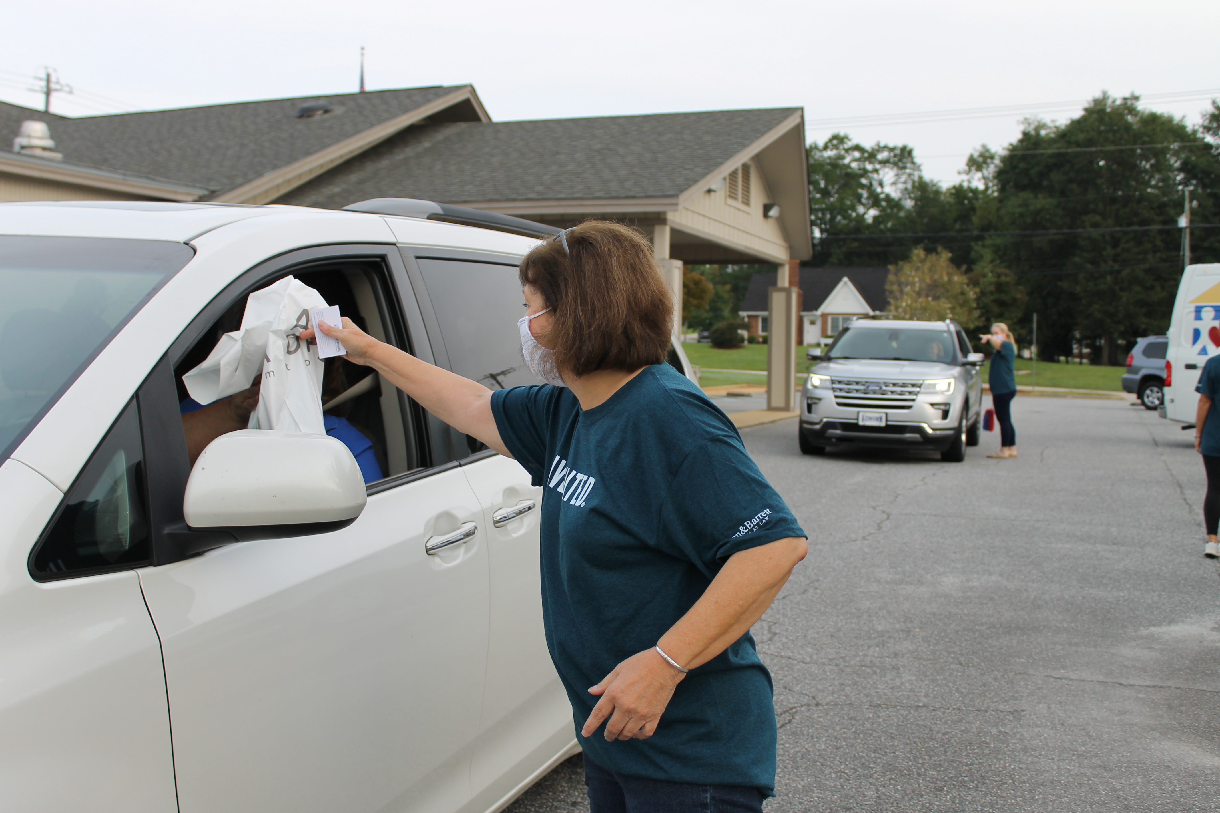 Executive Director Becky Benton delivers breakfast to an attendee