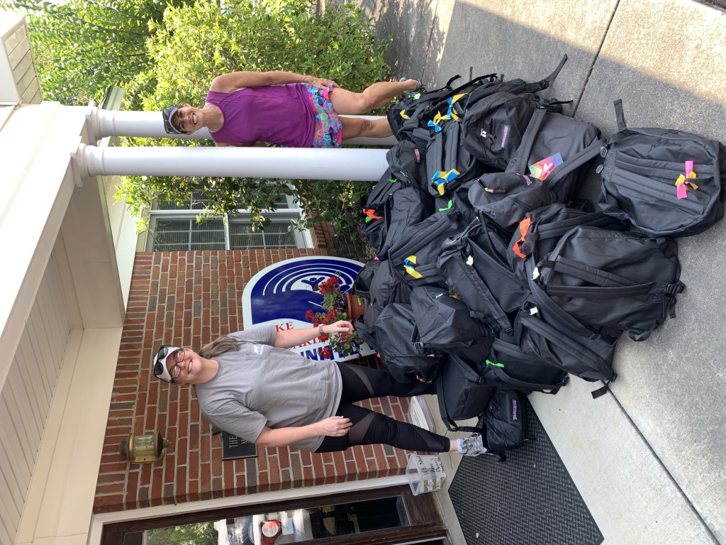 Volunteers transporting backpacks