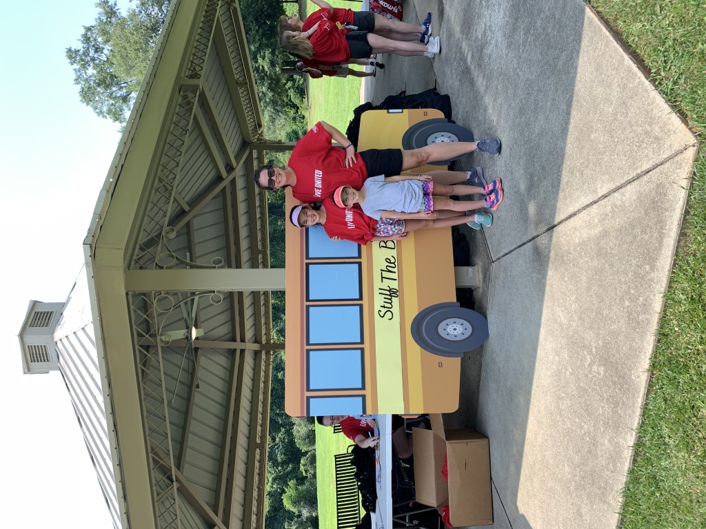 Volunteers posing in front of the school bus cutout